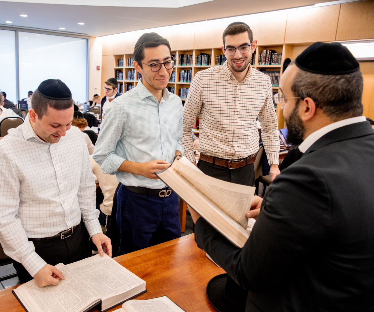 Three students learning from faculty member