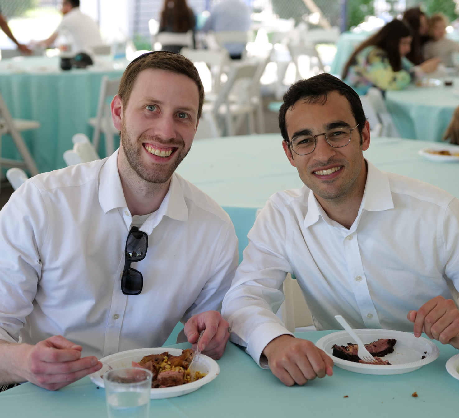 Two alums smiling while eating at table